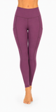 A person modeling high-waisted athletic leggings in a solid plum purple color, shown from the waist down against a plain white background.